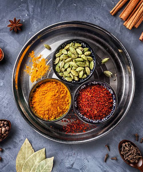 Various Spices like turmeric, cardamom, chili, bayberry, bay leaf, paprika, ginger, cinnamon, cumin, star anise and clove on grunge background